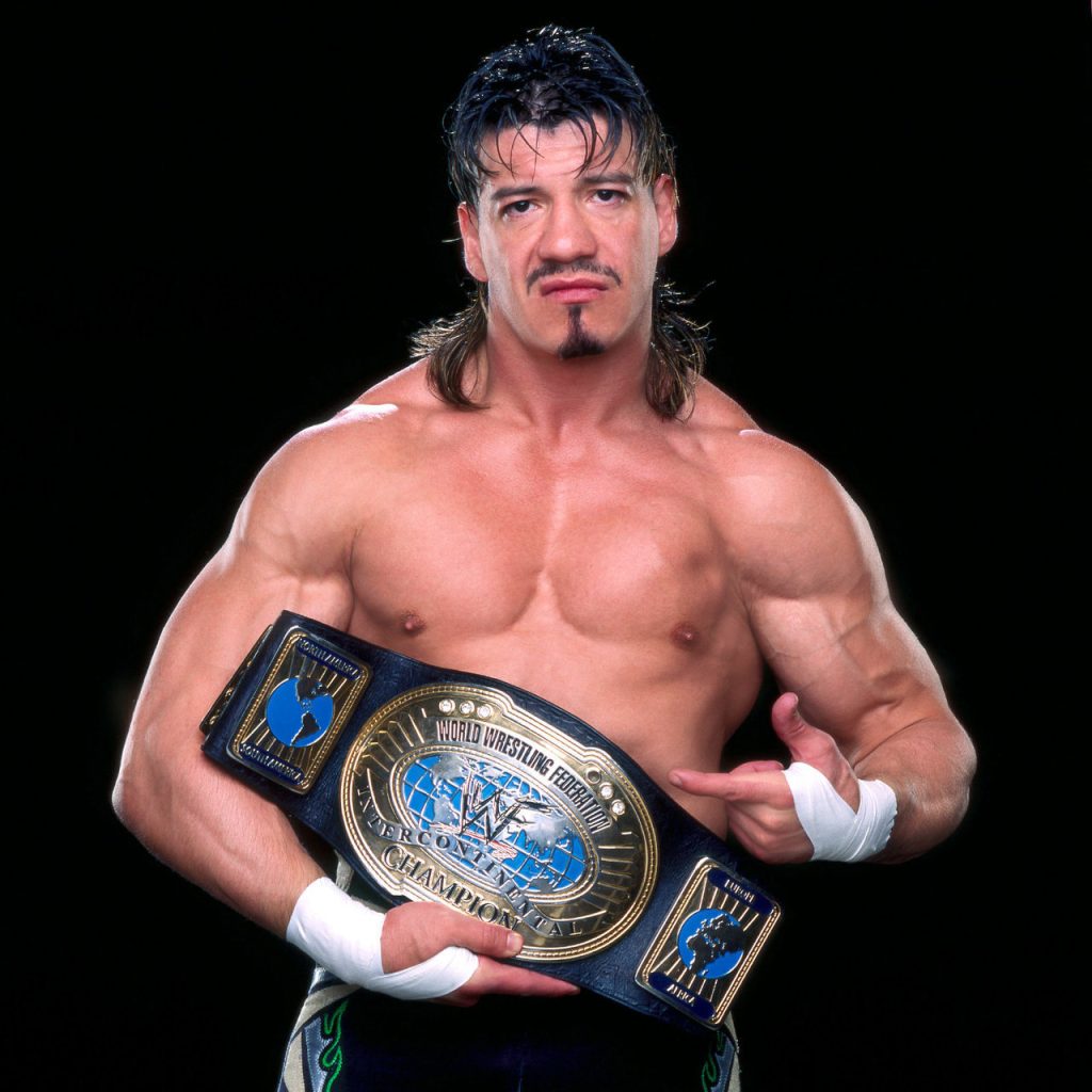 Eddie Guerrero points to his WWF Intercontinental Championship, mullet proudly adorning his head.
