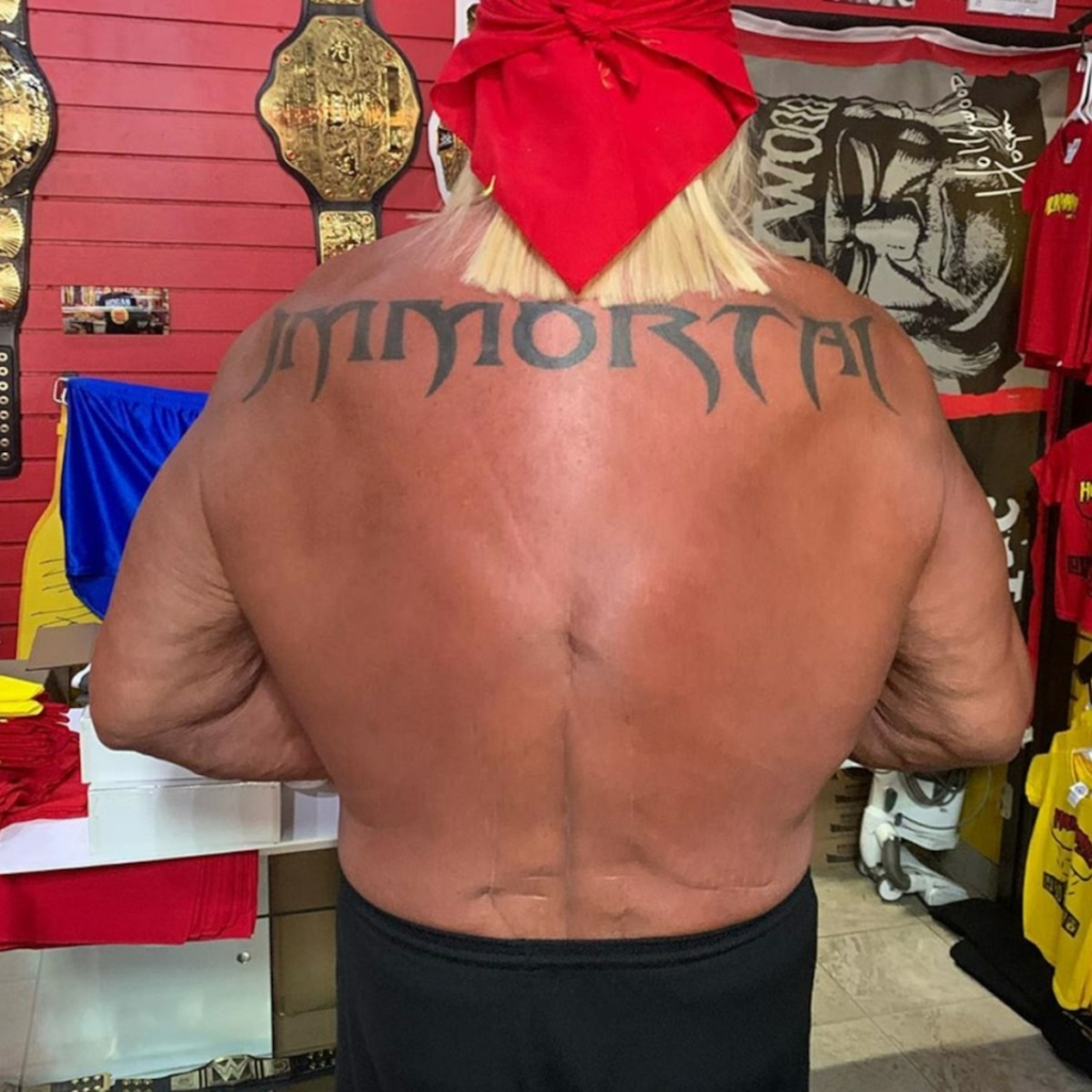 Hulk Hogan as pictured from behind, the word "immortal" tattooed across his shoulder blades, a broom-like jet of blonde hair peeking up from beneath his bandana.
