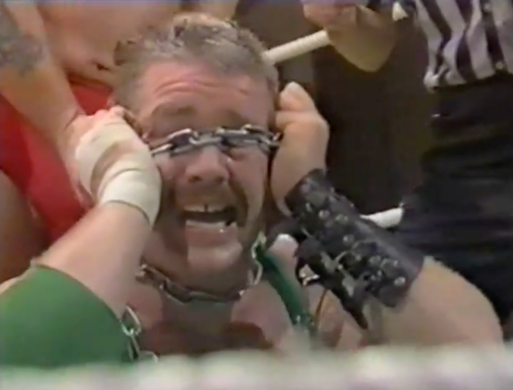 Fit Finlay screams in agony as a chain is wrapped around his eyes.