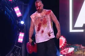 A bloody eddie kingston walks with purpose to the ring, carrying a gasoline can.