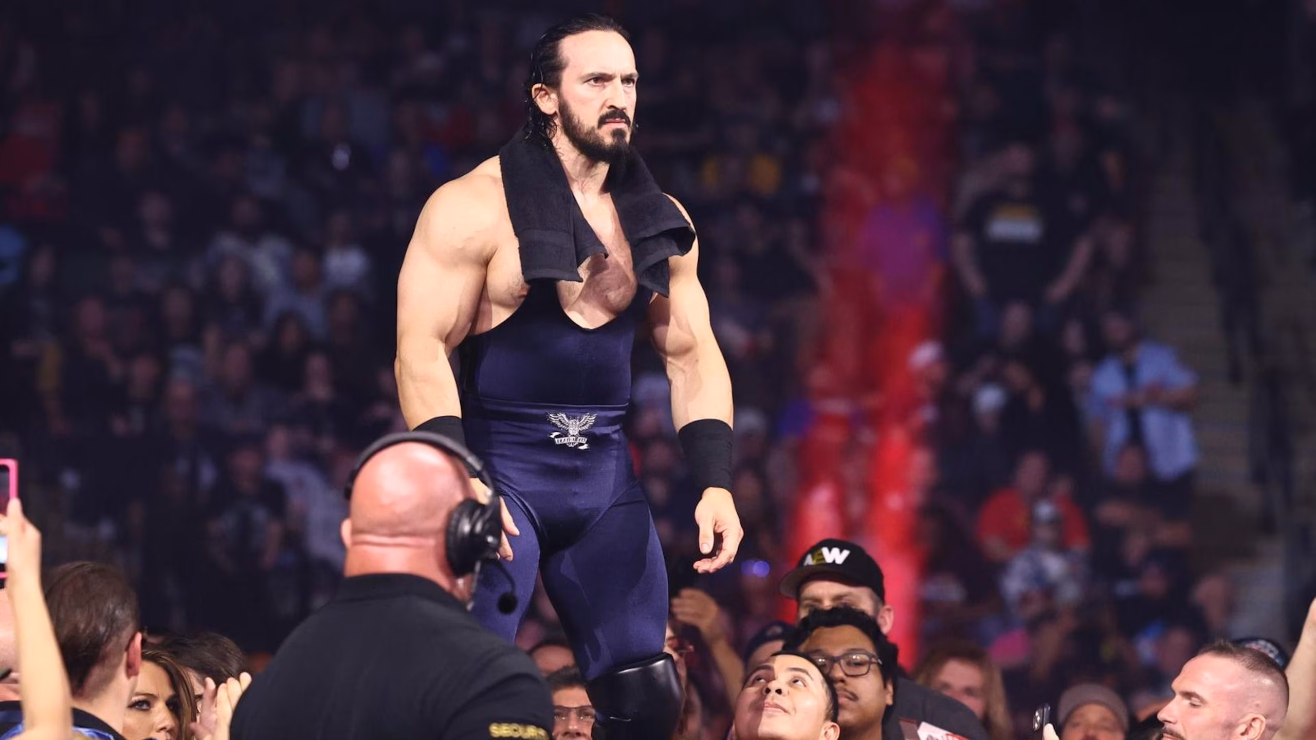 PAC, towel draped around his shoulders, stands on the turnbuckle surveying the ring ahead of his match against Andrade.